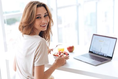 Kahvaltı ve laptop kamera seyir ile genç kadın arkadan görünüm