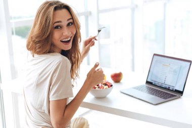 Genç kadın yemek yerken başparmak gösterilmesini