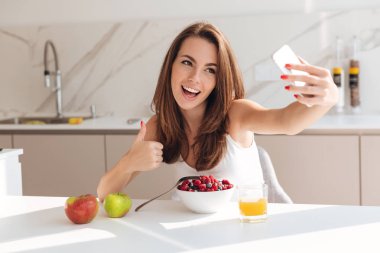 Bir selfie alarak ve başparmak gösterilmesini gülümseyen güzel kadın