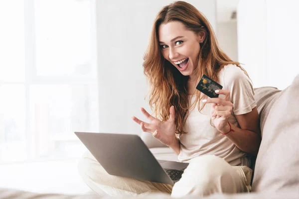 Sonriendo bonita mujer mostrando tarjeta de crédito a la cámara — Foto de Stock