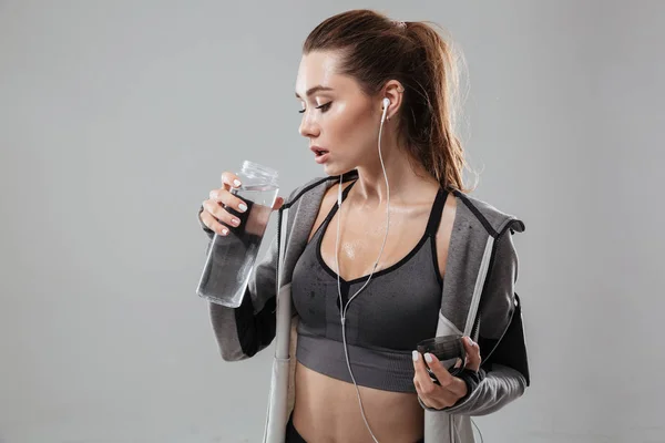 Joven mujer deportiva sosteniendo botella de agua —  Fotos de Stock