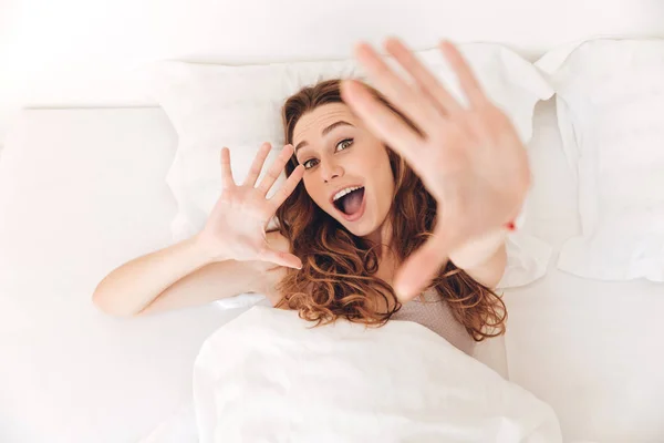 Vista superior de la joven feliz acostada en la cama — Foto de Stock