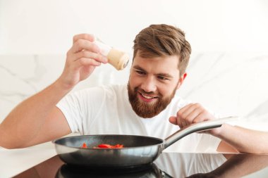 Gülümseyen sakallı adam sebze tuz serpin