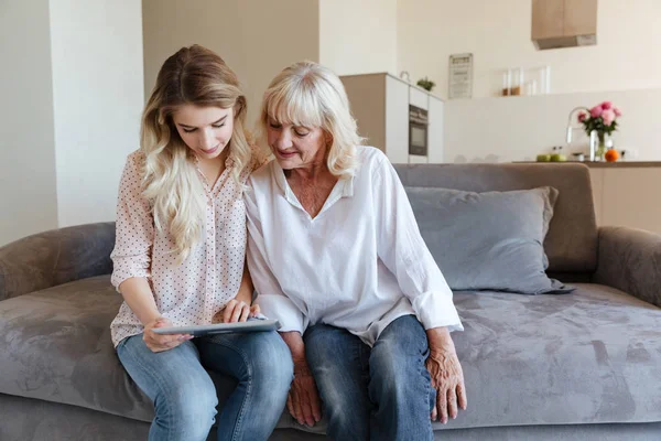 Veselá mladá dáma sedí doma s babičkou — Stock fotografie