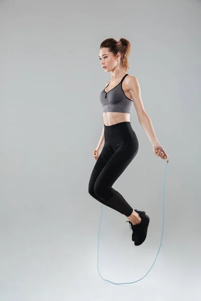 Full length image of a young sports woman jumping — Stock Photo, Image