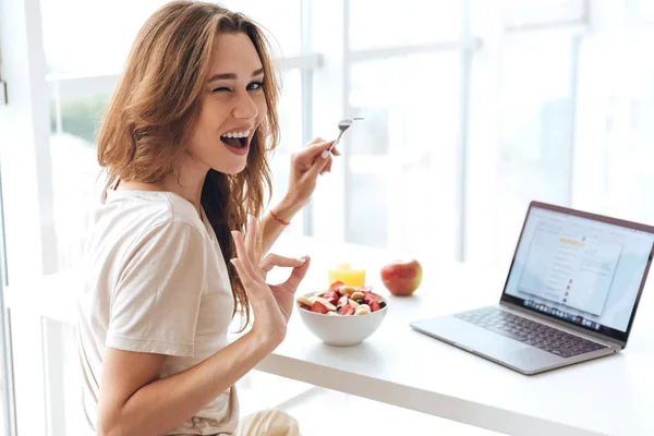 Mujer alegre guiñando un ojo y desayunar — Foto de Stock