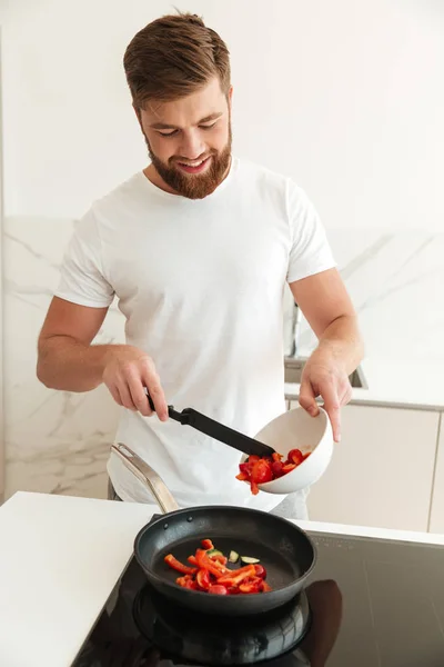 Image verticale de l'homme barbu heureux cuisson des légumes — Photo