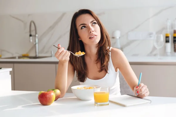 Jovem mulher pensativa tomando café da manhã cereal — Fotografia de Stock