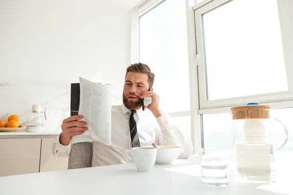 Serious bebaarde zakenman tijdschrift lezen — Stockfoto