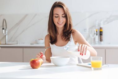 Genç kadın boşaltma sütü bir kaseye gülümseyen