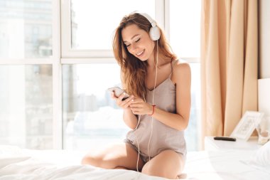 Akıllı telefon ve kulaklık kullanan genç kadın