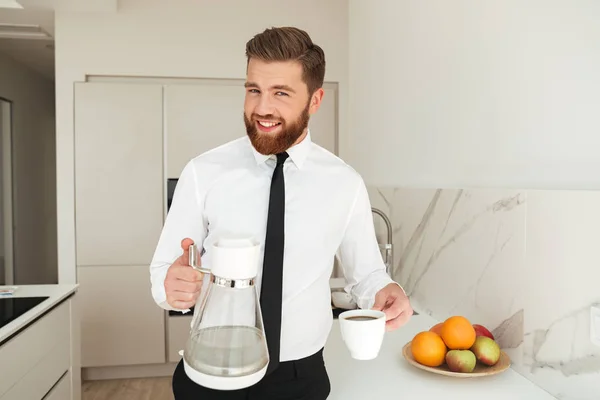 幸せな髭があるビジネスの男性がコーヒーを注ぐ — ストック写真