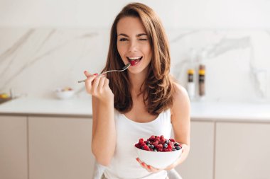 Oynak genç kadın holding kase taze çilek ile