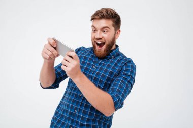 Kareli gömlek onun smartphone üzerinde oynarken mutlu sakallı adam