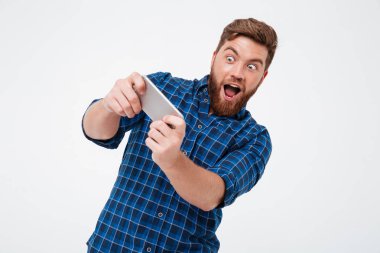 Onun smartphone üzerinde oynarken Kareli gömlekli şaşırmış sakallı adam