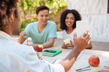 İki gülümseyen arkadaş smartphone vasıl arıyorsunuz