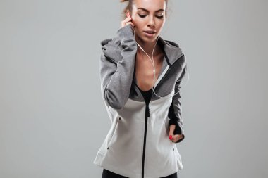 Sıcak genç kadın atlet çalışan ve dinleme müzik elbise