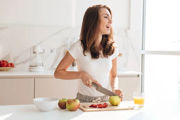 Sağlıklı genç kadın kesme meyve ahşap oyun tahtası — Stok fotoğraf