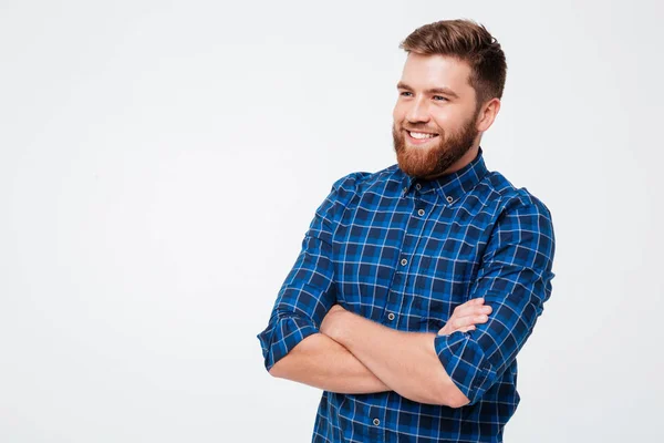 Молодий бородатий чоловік зі складеними руками посміхається до камери — стокове фото