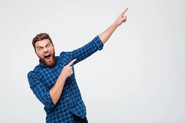 Gritando homem chocado apontando para o espaço de cópia — Fotografia de Stock