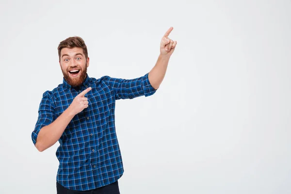 Happy man pointing at copy space isolated over white — Stock Photo, Image