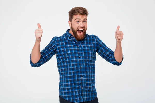 Счастливый кричащий бородатый мужчина показывает большие пальцы вверх — стоковое фото