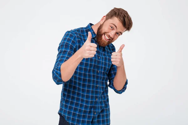 Uomo barbuto sorridente in camicia a scacchi mostrando pollici in su — Foto Stock