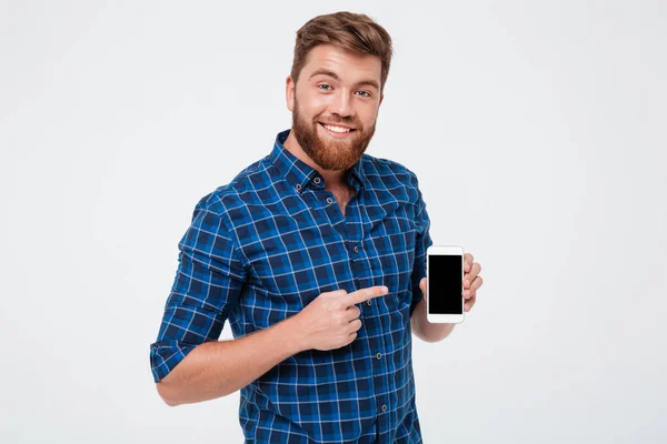 Lachende bebaarde man in geruite hemd leeg smartphone scherm tonen — Stockfoto