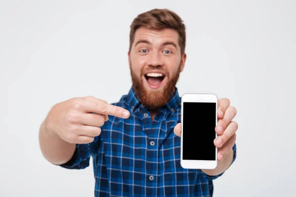 Homem barbudo feliz em camisa quadriculada mostrando tela de smartphone em branco — Fotografia de Stock