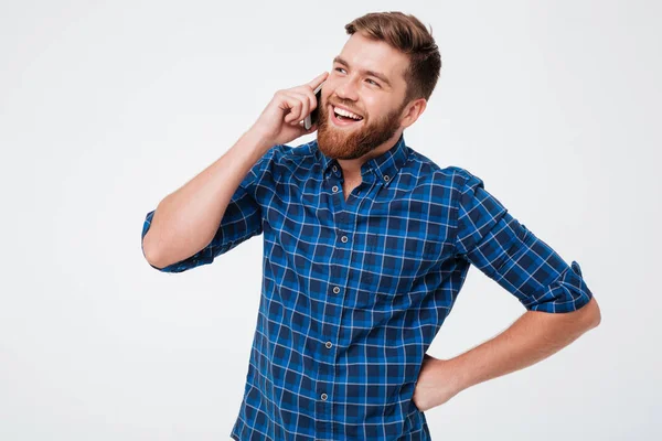 Hombre barbudo feliz con camisa a cuadros hablando por el teléfono inteligente —  Fotos de Stock