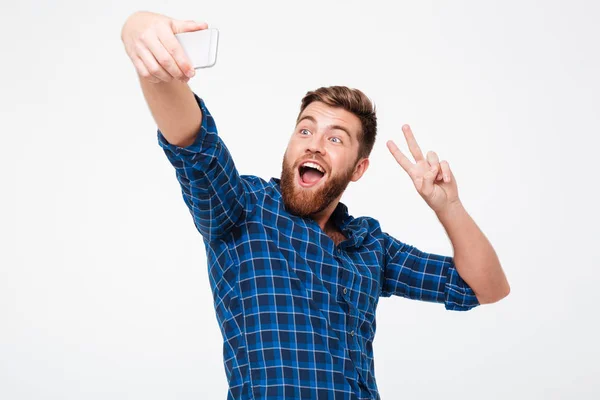 スマート フォンで selfie を作ると平和を示す幸せなのひげを生やした男 — ストック写真