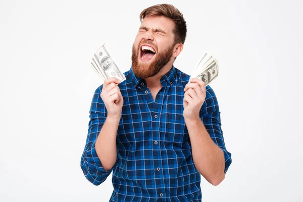 Кричащий бородатый мужчина в клетчатой рубашке с деньгами в руке — стоковое фото