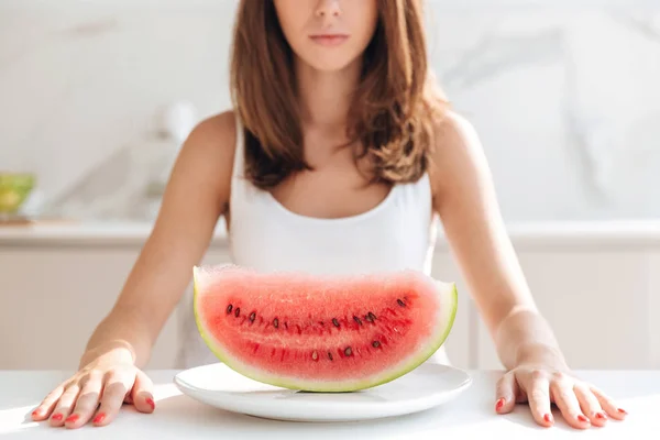 Young woman sitting at the kitchen table — Stock Photo, Image