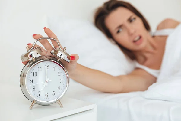 Nahaufnahme einer Frau, die den Wecker ausschaltet — Stockfoto