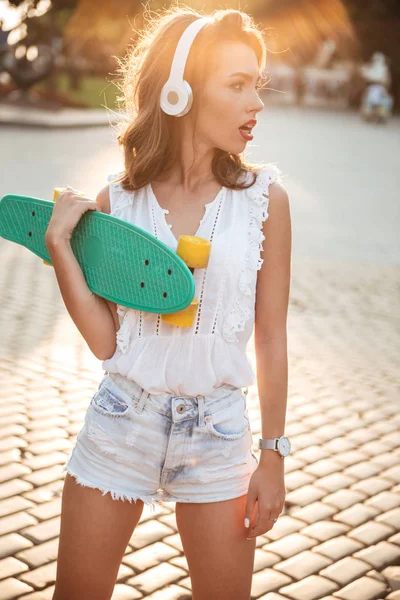 야외에서 스케이트 보드를 들고 놀라운 젊은 여자. — 스톡 사진
