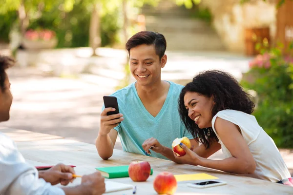 Três amigos rindo sentados à mesa — Fotografia de Stock