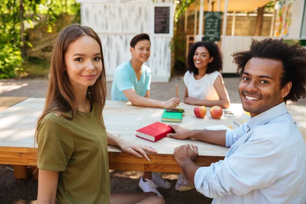 Dört genç mutlu arkadaş masanın tarafından açık havada
