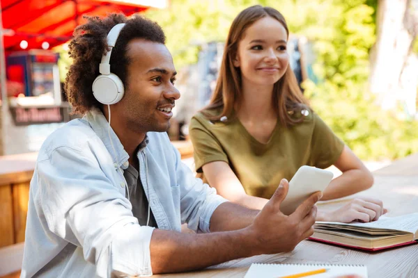 İki genç arkadaşlar tarafından masanın gülümseyen yan görünüm