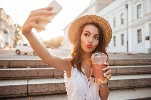 Genç ve güzel kadın açık havada telefonla selfie olun