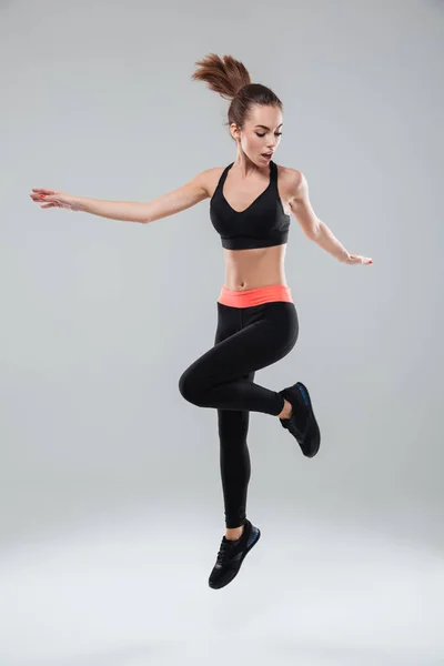 Imagen completa de una mujer deportista saltando en el estudio — Foto de Stock