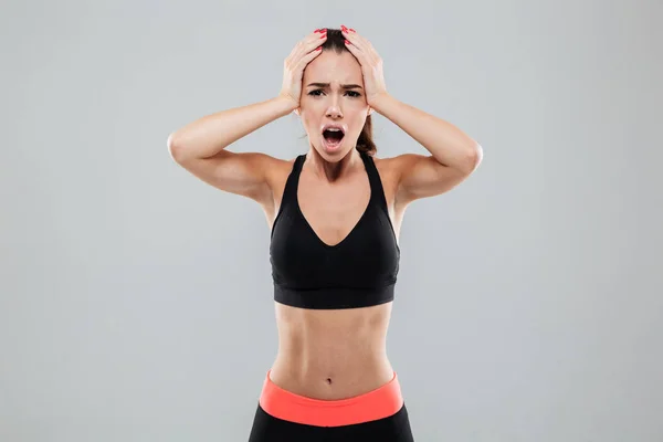 Shocked sports woman holding her head — Stock Photo, Image