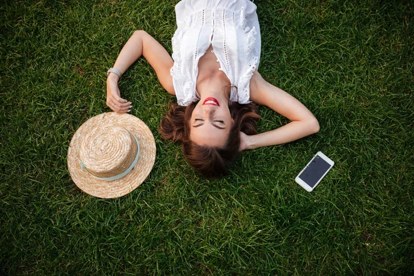 Kobieta leży na trawie na zewnątrz. Zamkniętymi oczami. — Zdjęcie stockowe