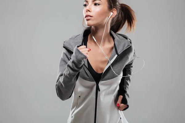 Hübsche Läuferin in warmer Kleidung läuft im Studio — Stockfoto