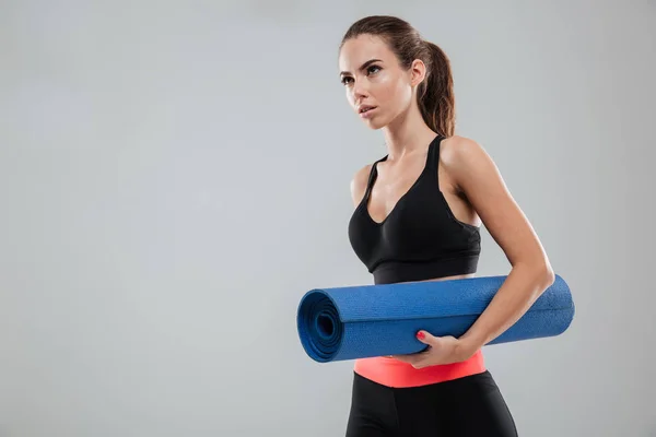 Serious fitness woman with fitness mat — Stock Photo, Image