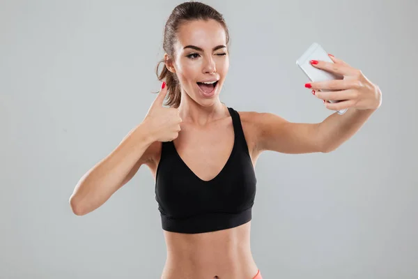 Kobieta szczęśliwa fitness podejmowania selfie na swoim smartfonie — Zdjęcie stockowe
