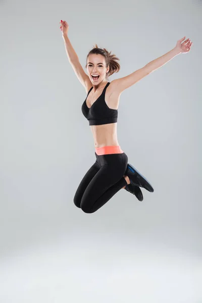 Imagem de comprimento total da mulher de fitness de salto feliz — Fotografia de Stock