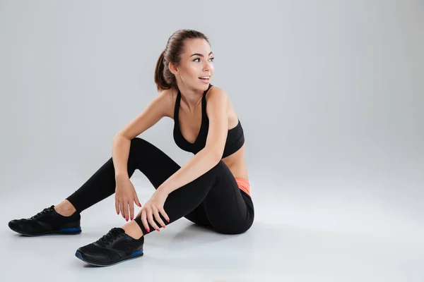 Sorrindo Fitness mulher relaxante no chão em estúdio — Fotografia de Stock