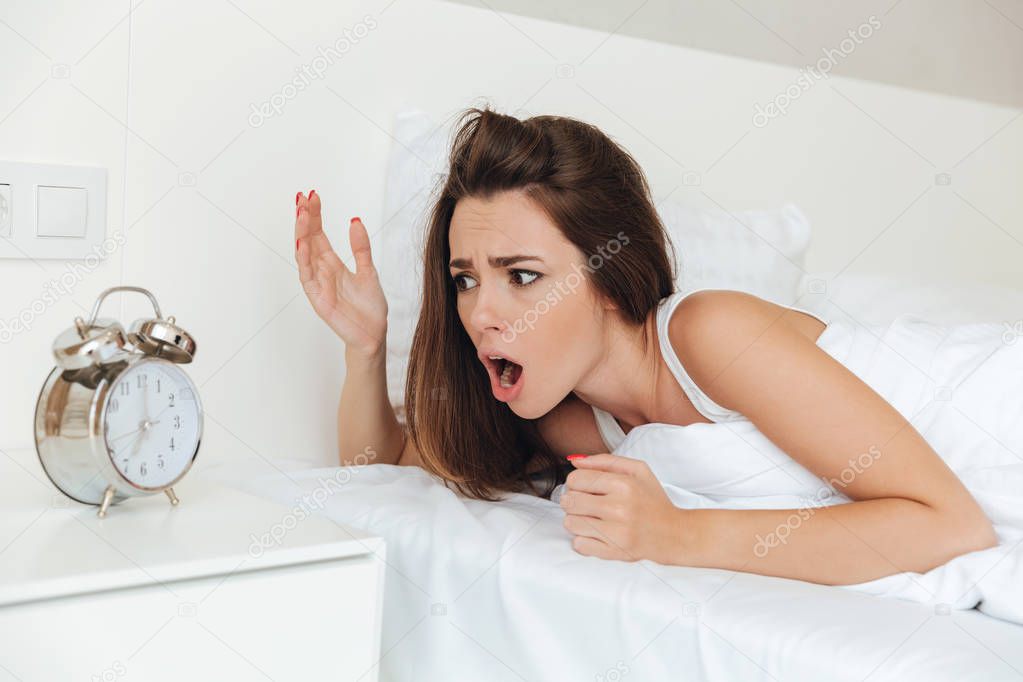 Confused woman laying in bed in the morning