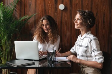 İki kıvırcık kadın tarafından tablo çalışma