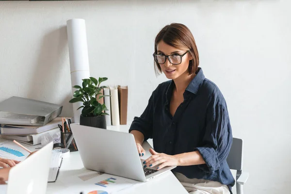 Mulher de beleza calma em óculos usando computador portátil — Fotografia de Stock